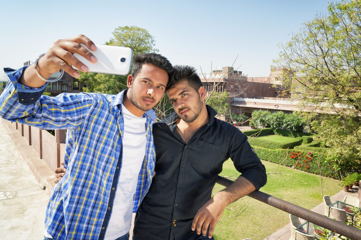 Two young Indian men taking a selfie together.